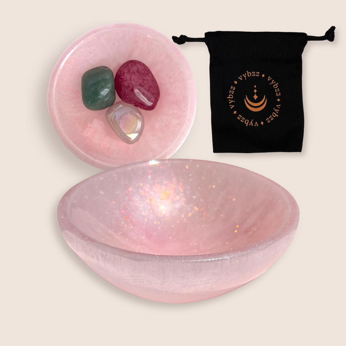 Pink selenite crystal bowl set with three polished gemstones and black drawstring pouch