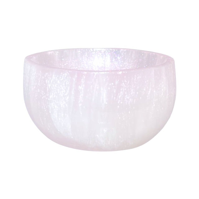 A round selenite crystal bowl, featuring a hand-painted  shimmering pink finish.