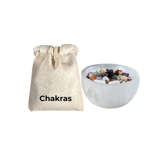 A Chakra Pocket Pouch with a selenite bowl featuring scolecite, amethyst, celestite, green aventurine, sunstone, carnelian, and black tourmaline crystals for balancing chakras.