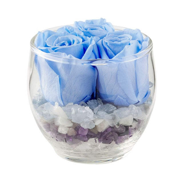 The Blooming Crystal Tranquility Vaz has layers of celestite, rainbow moonstone, amethyst, selenite and clear quartz crystals, topped with dreamy blue ForeverFloret preserved roses. 