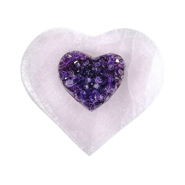 A stunning selenite heart charging plate featuring a mesmerizing pink shimmery finish. Adorned with a beautiful AAA-grade, 15mm amethyst heart at the center,  the perfect crystal for cleansing and charging your crystals.