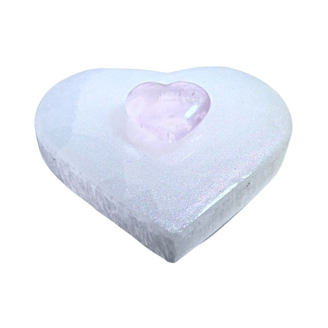 Side view of a pink-shimmery coated selenite heart charging plate with a puffy rose quartz heart in the center. Perfect for crystal lovers and energy enthusiasts.