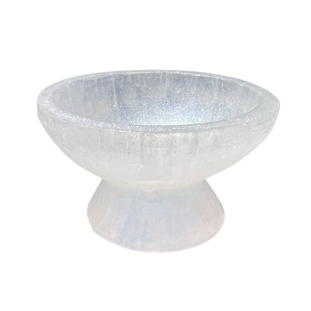  The side view of a petite pedestal, selenite crystal bowl, hand adorned with a custom opalescent finish.