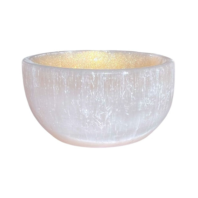 A selenite crystal bowl, hand adorned with a golden finish.
