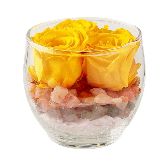 A Blooming Crystal Bliss Vaz, filled with layers of sunstone, rose quartz, green aventurine, selenite and clear quartz crystals, topped with yellow ForeverFloret preserved roses.
