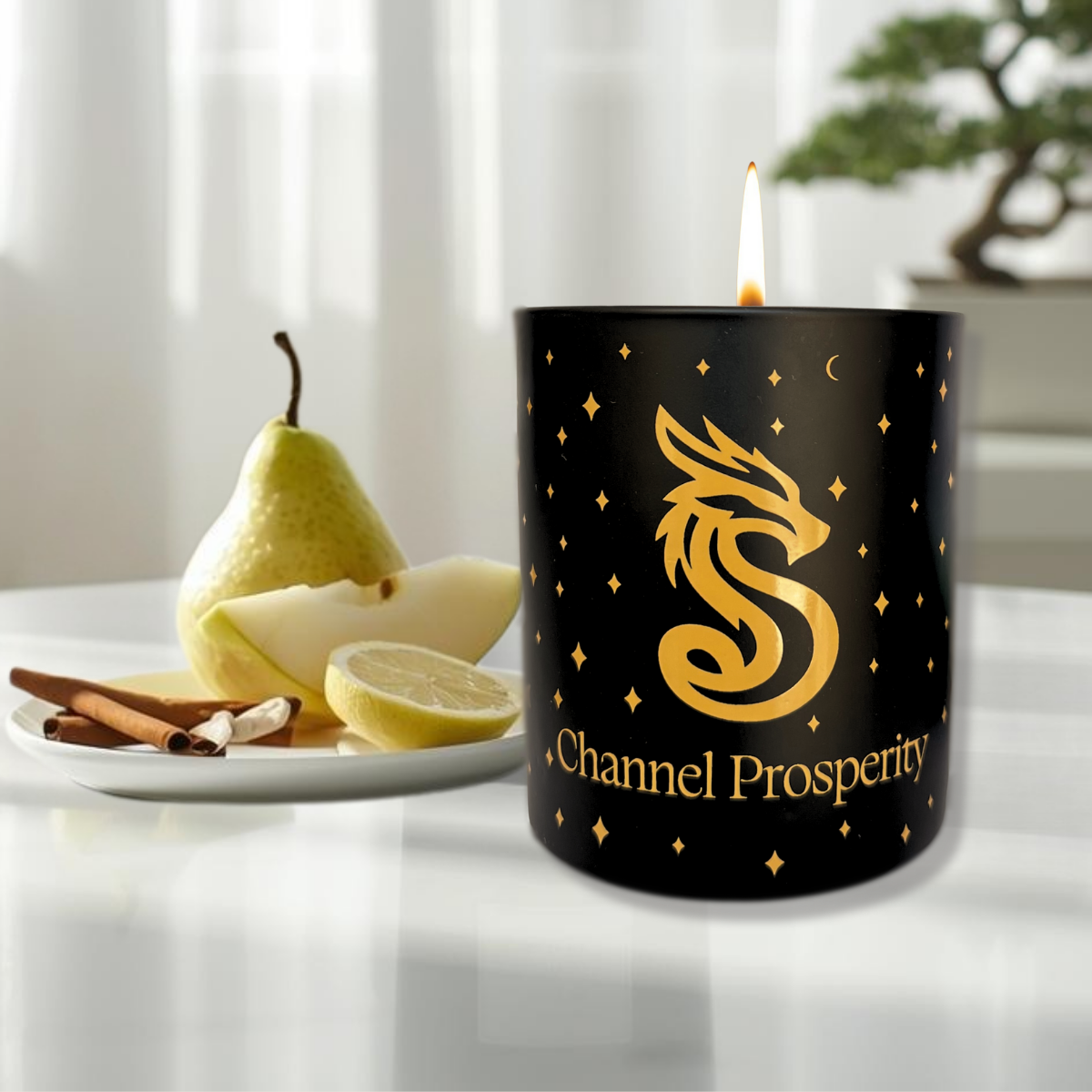 Channel Prosperity aromatherapy candle with dragon icon. A pear, lemon and cinnamon sticks on plate.